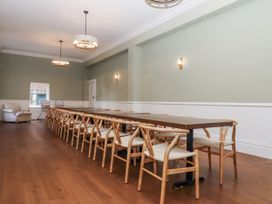 A dining room with a long table and chairs at Alston Hall Battisborough Cross
