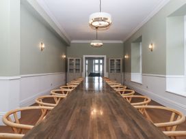 A dining room with a long table and chairs at Alston Hall Battisborough Cross