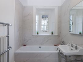 A bathroom with a bathtub and sink at Alston Hall Battisborough Cross