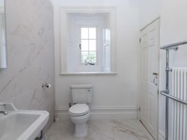 A bathroom with a toilet and bathtub at Alston Hall Battisborough Cross