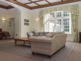 A living room with a sofa, table, and armchair at Alston Hall near Mothecombe Beach