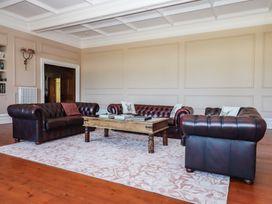 A living room with leather sofas and a wooden coffee table at Alston Hall near Mothecombe Beach