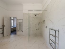 A bathroom with a shower and radiator at Alston Hall near Mothecombe Beach