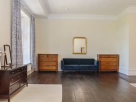 A living room with a sofa and dressers at Alston Hall near Mothecombe Beach