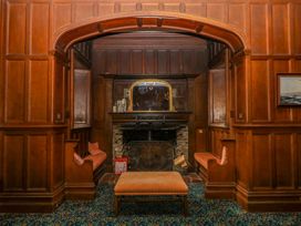 A sitting room with a fireplace and armchairs at Alston Hall near Mothecombe Beach