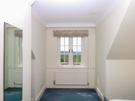 A bedroom with a window and a mirror at Alston Hall near Mothecombe Beach