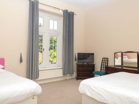 A bedroom with two beds and a television at Alston Hall near Mothecombe Beach