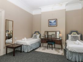 A bedroom with two single beds and a wooden desk at Alston Hall near Mothecombe Beach