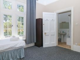 A bedroom with a bed and wardrobe at Alston Hall near Mothecombe Beach