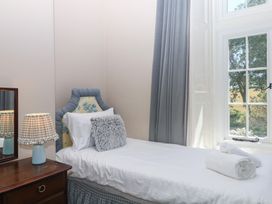 A bedroom with a single bed and a lamp at Alston Hall near Mothecombe Beach