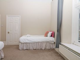 A bedroom with a bed and door at Alston Hall near Mothecombe Beach