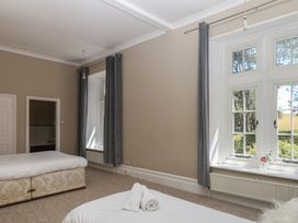 A bedroom with beds and windows at Alston Hall near Mothecombe Beach