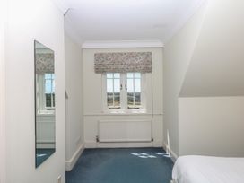 A bedroom with a window and a mirror at Alston Hall near Mothecombe Beach