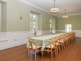 A dining room with a long table and chairs at Alston Hall near Mothecombe Beach