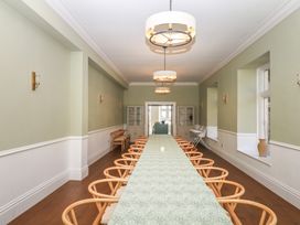 A dining room with a long table and chairs at Alston Hall near Mothecombe Beach