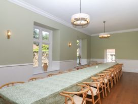 A dining room with a long table and chairs at Alston Hall near Mothecombe Beach