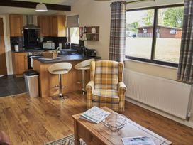A kitchen with a counter, bar stools, and a chair at Cowslip in Saltburn-By-The-Sea