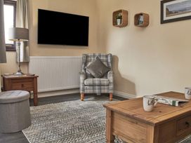 A living room with an armchair and coffee table at Cowslip in Saltburn-By-The-Sea