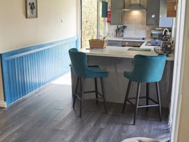 A kitchen with bar stools and a counter at Cowslip in Saltburn-By-The-Sea