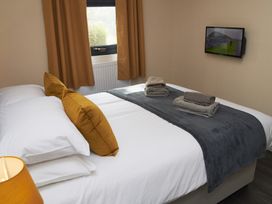 A bedroom with a bed and television at Cowslip in Saltburn-By-The-Sea