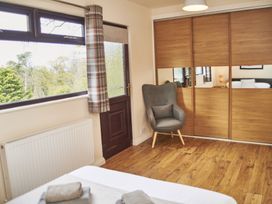 A bedroom with a chair and wardrobe at Cowslip in Saltburn-By-The-Sea