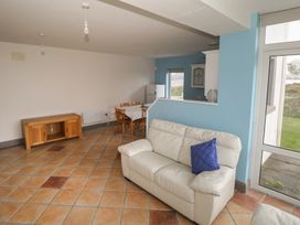 A living room with a sofa and a dining area at No.5 Beach Cottages in Keel, County Mayo