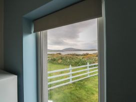 A window with a view of the water and grass at No.5 Beach Cottages, Keel, County Mayo