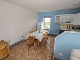 A dining table with chairs in a kitchen at No.5 Beach Cottages Keel, County Mayo