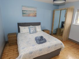A bedroom with a bed and a mirror wardrobe at No.5 Beach Cottages in Keel, County Mayo