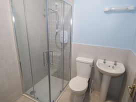 A bathroom with a shower, toilet, and sink at No.5 Beach Cottages in Keel, County Mayo