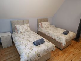 A bedroom with two single beds and bedside tables at No.5 Beach Cottages, Keel, County Mayo