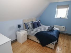 A bedroom with a bed and bedside table at No.5 Beach Cottages, Keel, County Mayo