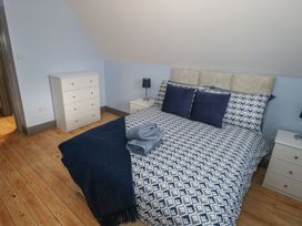 A bedroom with a bed and dresser at No.5 Beach Cottages in Keel, County Mayo