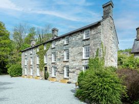 A stone building with windows and a door at Snowdonia Manor in Dolgellau