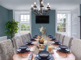 A dining room with a long table set for a meal at Snowdonia Manor in Dolgellau