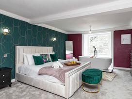 A bedroom with a bed and a bathtub at Snowdonia Manor in Dolgellau