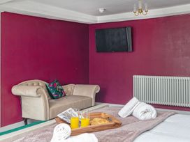 A bedroom with a sofa and TV at Snowdonia Manor in Dolgellau