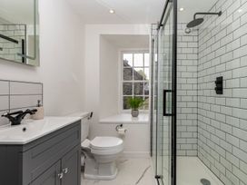 A bathroom with a sink, toilet, shower and window at Snowdonia Manor in Dolgellau