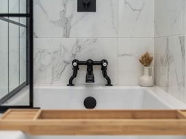 A bathroom with a bathtub and a faucet at Snowdonia Manor in Dolgellau
