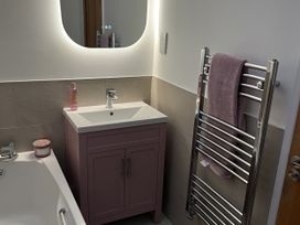 A bathroom with a vanity sink and towel rail at Seascape in Kingsand