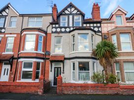 A house with multiple windows and a palm tree at Curzon Heights in Llandudno