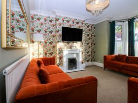 A living room with sofas and a fireplace at Curzon Heights in Llandudno