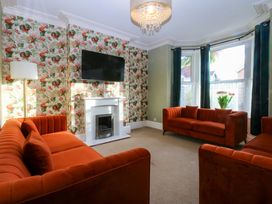 A living room with sofas and a television at Curzon Heights in Llandudno