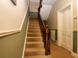 A staircase with a handrail in a hallway at Curzon Heights, Llandudno