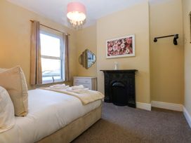 A bedroom with a bed, mirror, and fireplace at Curzon Heights in Llandudno