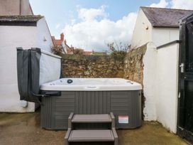 A hot tub with steps beside a wall at Curzon Heights in Llandudno
