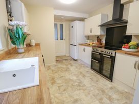 A kitchen with a sink, countertop, refrigerator, and an oven at Curzon Heights in Llandudno