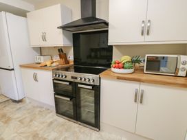 A kitchen with an oven, refrigerator, and microwave at Curzon Heights, Llandudno
