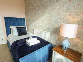 A bedroom with a single bed and bedside lamp at Curzon Heights in Llandudno