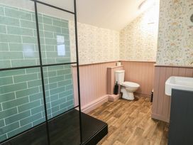 A bathroom with a shower, toilet, and sink at Curzon Heights in Llandudno